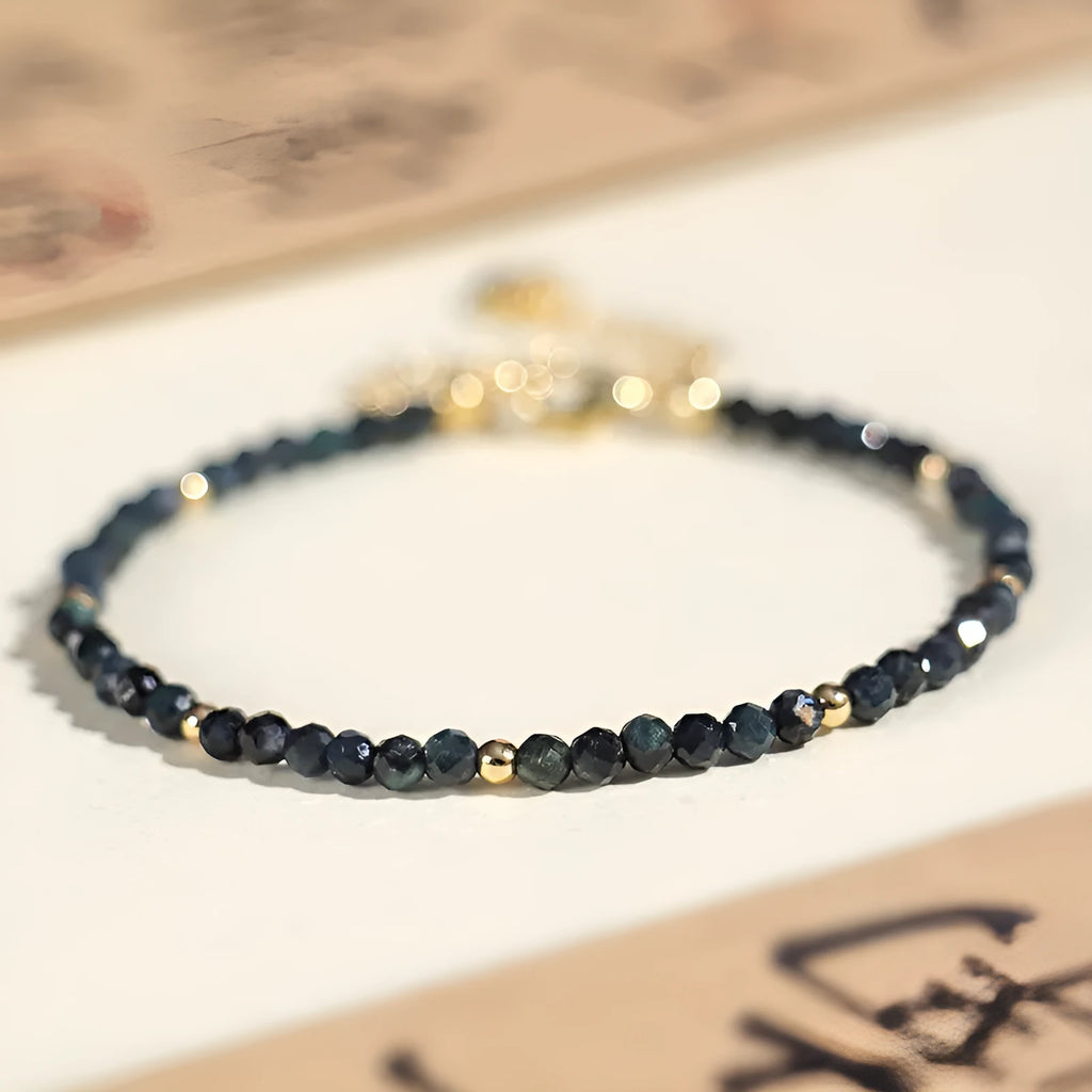 3mm blue tourmaline cut bead bracelet with spacer beads on a wrist