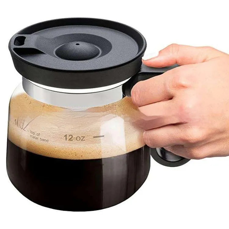 Transparent borosilicate glass coffee maker with black silicone cover on a kitchen counter