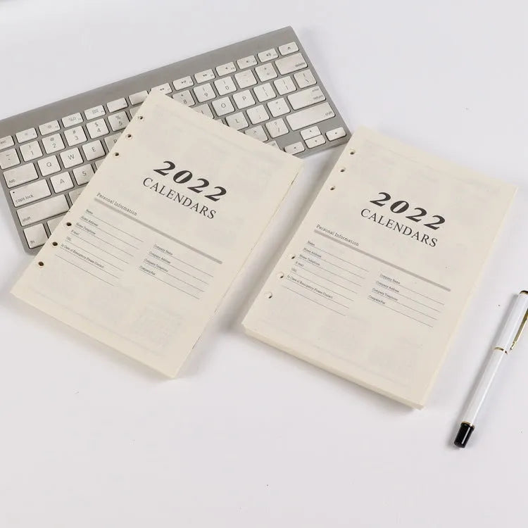 White A5 loose-leaf notebook inner pages with monthly plan layout on a plain background
