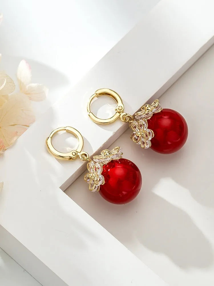 A pair of women's geometric copper earrings with a rose design and small zircon stone accents.