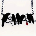 Black electroplated alloy crow pendant necklace on a cross chain for women.