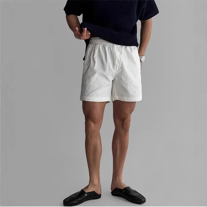 Men's loose-fit cotton sports shorts in khaki colour on a white background.