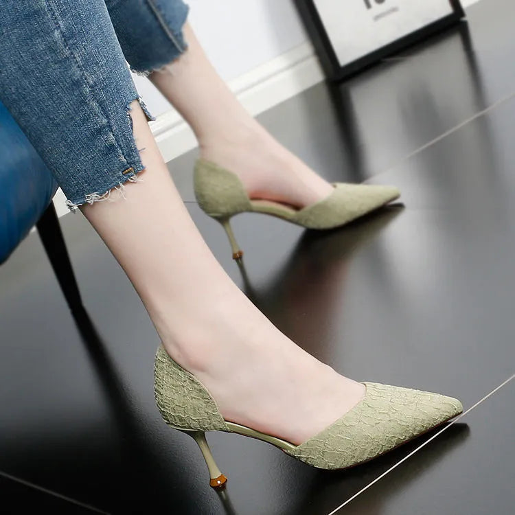 Women's black pointed leather high heel shoes with a stiletto heel on a plain background.
