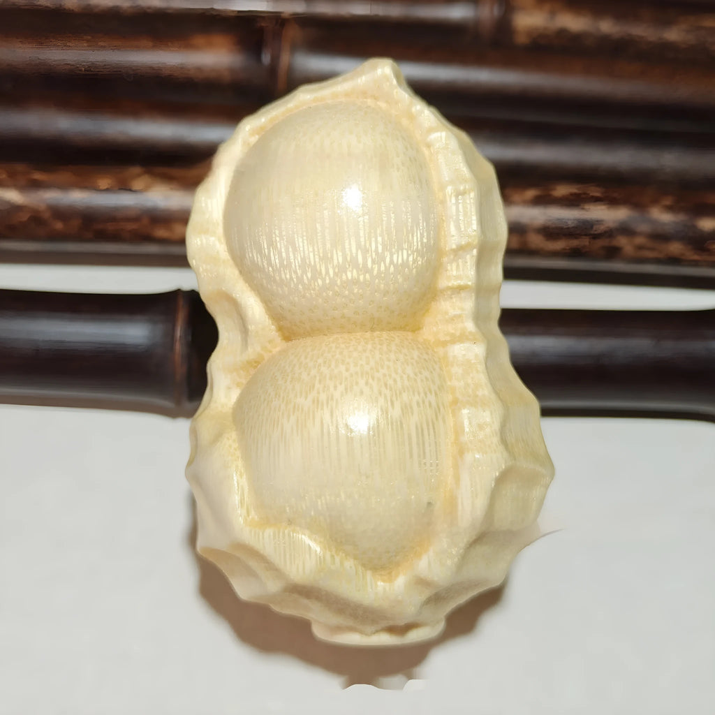 Solid natural bamboo carved peanut ornament with modern simple design on a wooden surface.