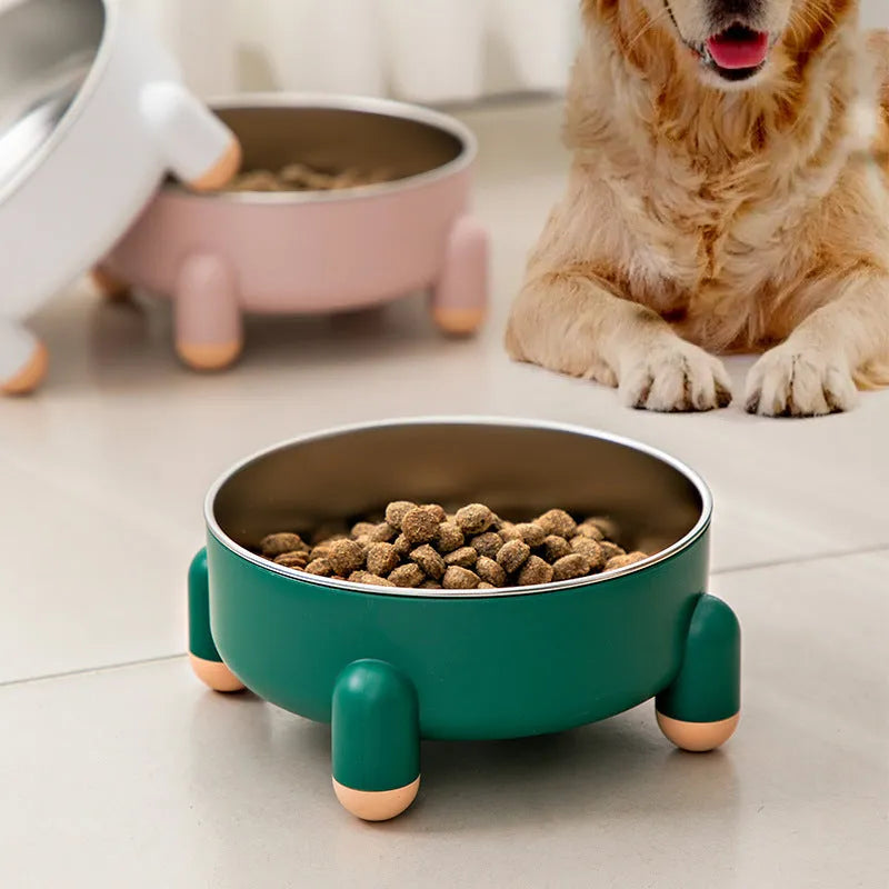Green stainless steel pet bowl with a high foot and non-slip base on a kitchen floor.