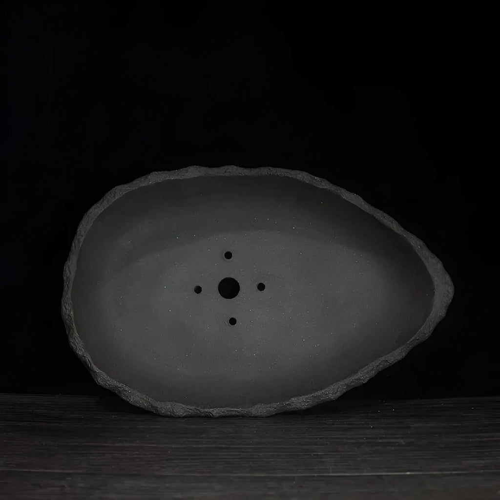 Handmade purple clay flower pot showing unique shape and natural clay texture