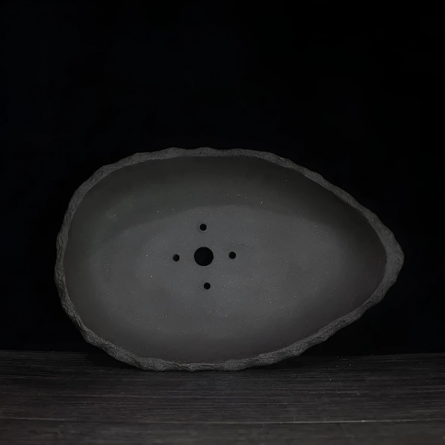 Handmade purple clay flower pot showing unique shape and natural clay texture