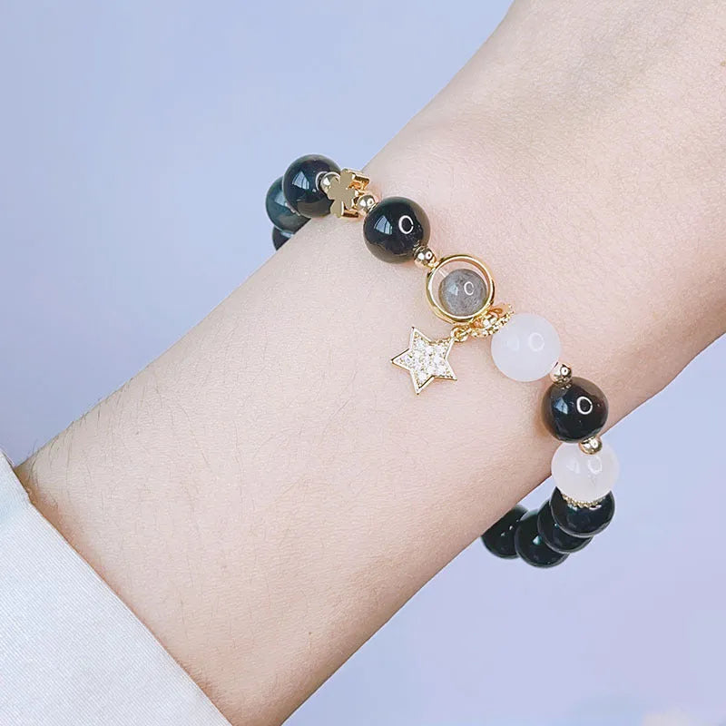Adjustable silver stone bracelet for women with choice of flower, love, or star charm on a white background.