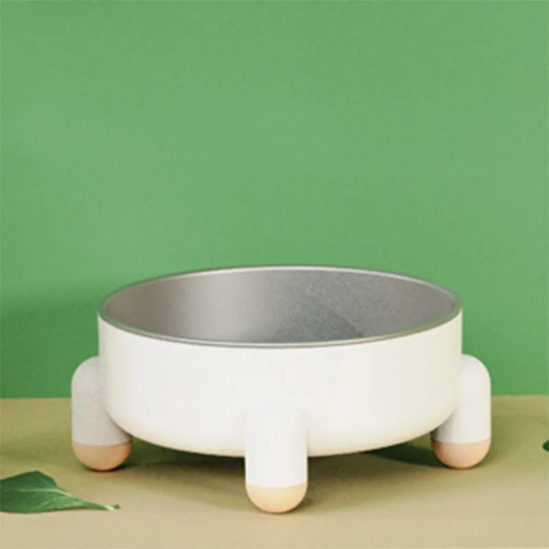 Green stainless steel pet bowl with a high foot and non-slip base on a kitchen floor.