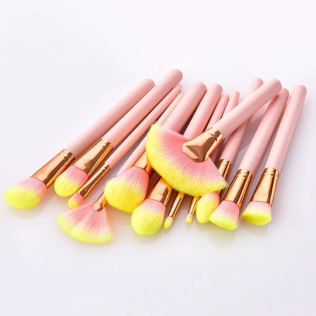Pink 10-piece makeup brush set with nylon wool bristles and wooden handles laid out on a flat surface
