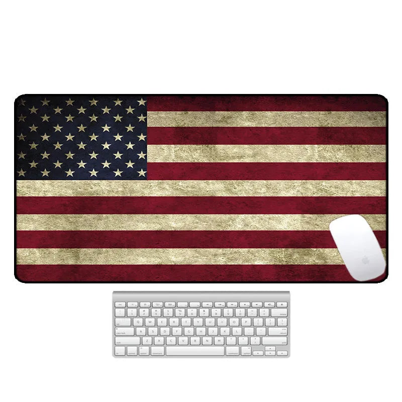 Large black rubber desk mouse pad with a printed geometric pattern, shown on a wooden desk.