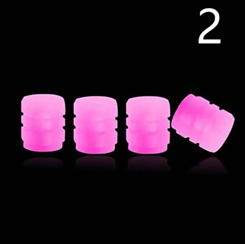 Pack of green and blue luminous rubber tyre valve caps on a car tyre valve.