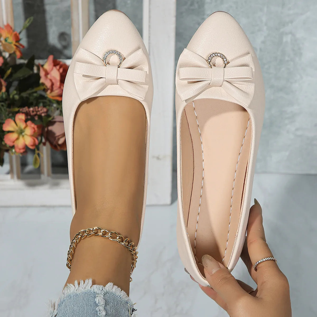 Women's beige flat casual slip-on shoes with a bowknot and shallow mouth design on a white background.