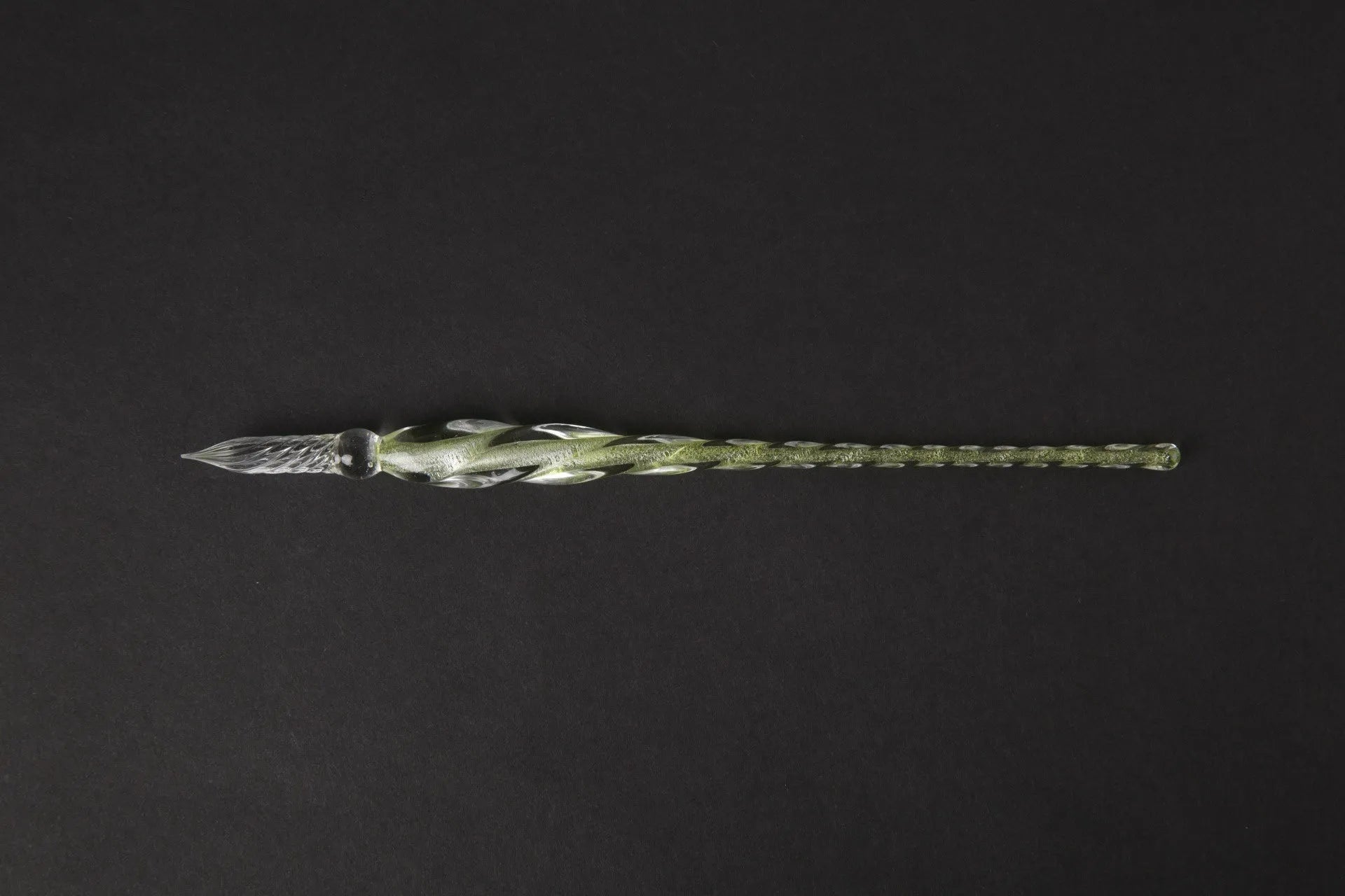Hand-blown glass crystal pen with coloured ink in a transparent barrel on a gift box.