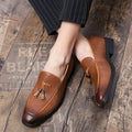 Men's black pointed slip-on business shoes with tassel detail on artificial PU upper.