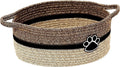 Light beige handmade woven cotton rope storage basket with handle on a wooden surface.