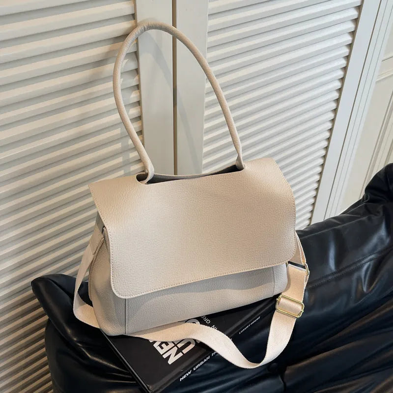 PU leather tote bag in beige with double shoulder strap and visible stitching detail.