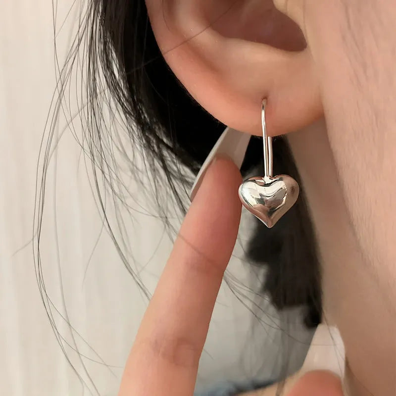 Silver colour heart-shaped earrings with glossy finish and three-dimensional Korean style design