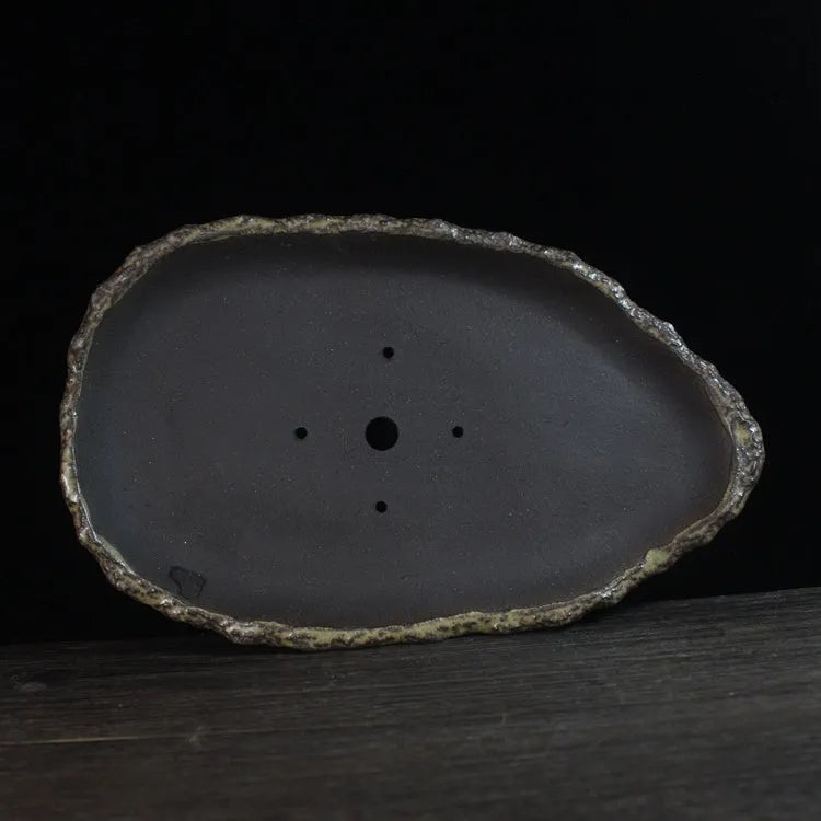 Handmade purple clay flower pot showing unique shape and natural clay texture