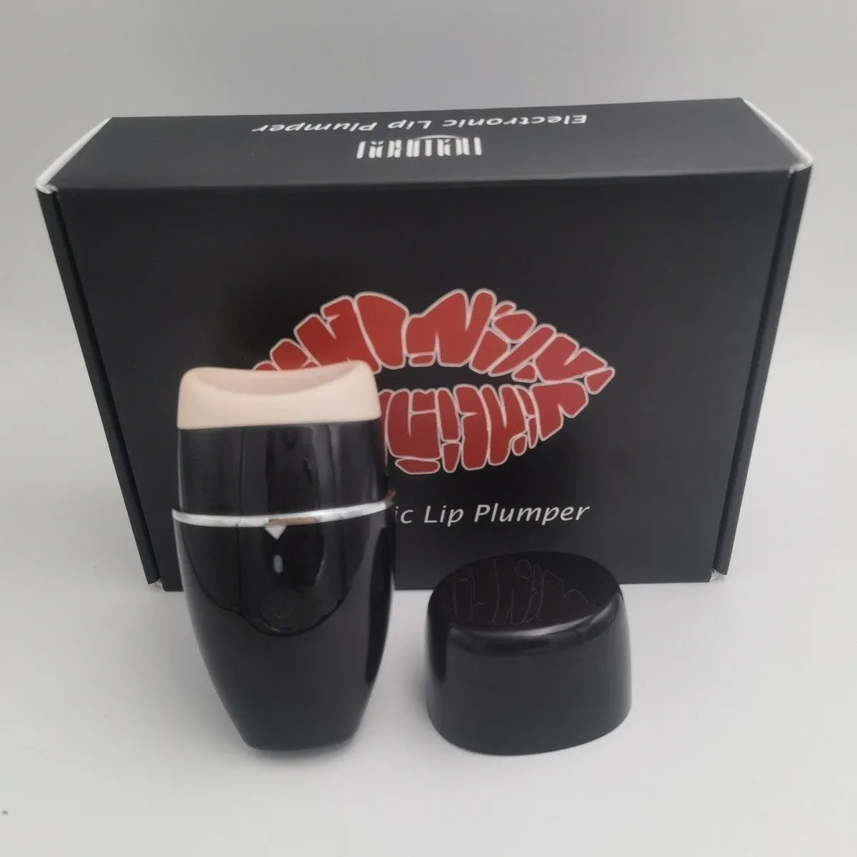 Black and white electric silicone lip plumper device with USB cable.