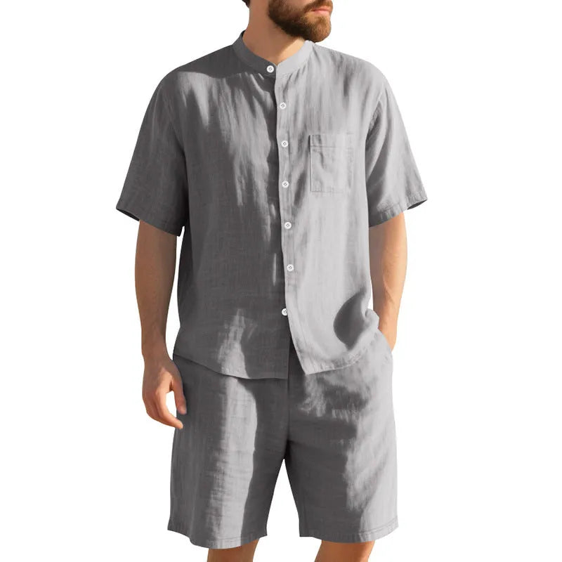 Man wearing a light blue short-sleeve linen blend suit jacket and matching shorts with a Henry collar.