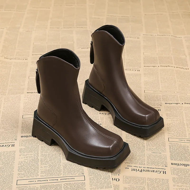Black women's platform Martin ankle boots with a square toe, high heel, and back zipper on a white background.
