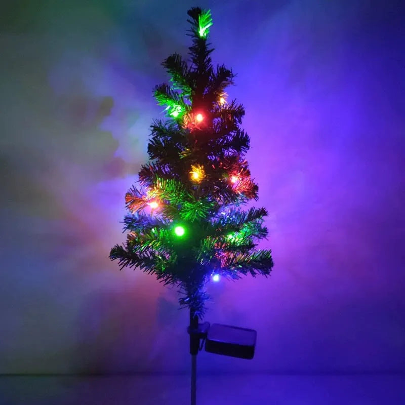 Solar Christmas tree lamp with ABS body placed on grass in a garden setting