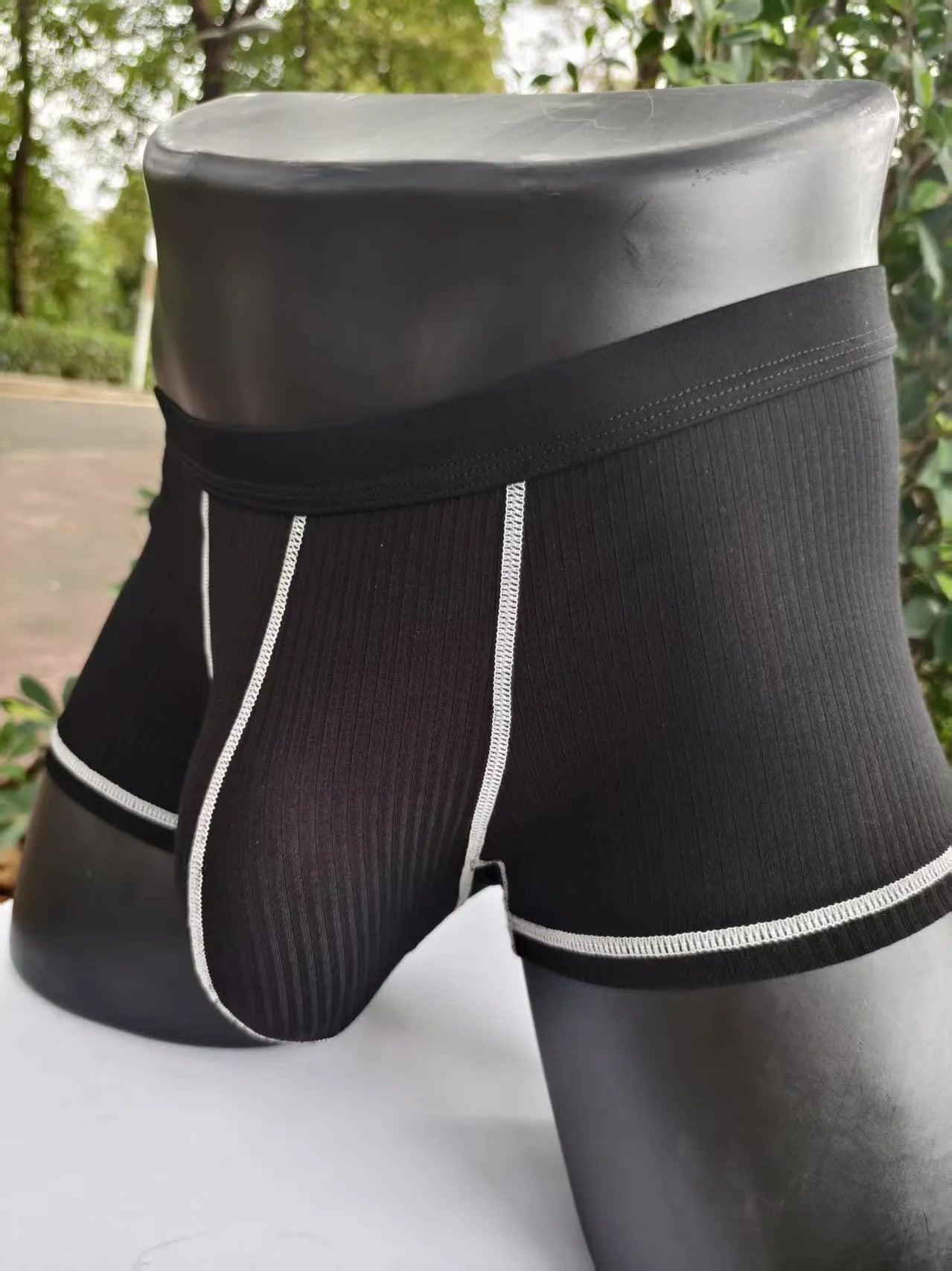 Solid colour men's boxers on a white background, showing thin breathable fabric and body-shaping fit.