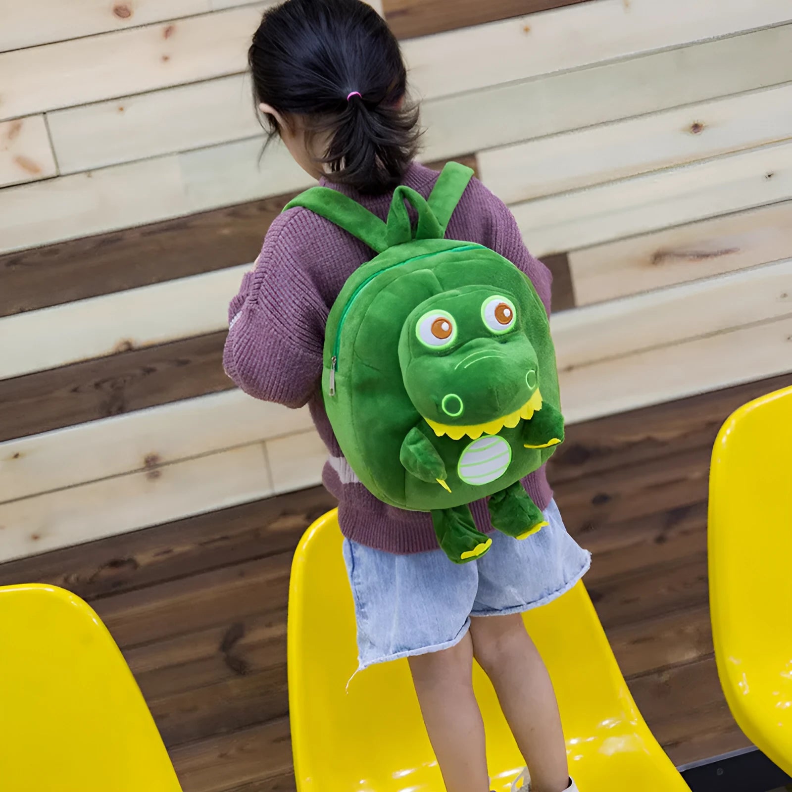 Colourful dinosaur plush backpack for children with soft handle and embroidery detail.