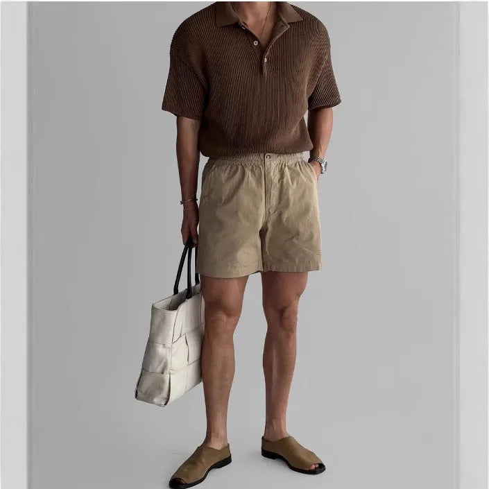 Men's loose-fit cotton sports shorts in khaki colour on a white background.