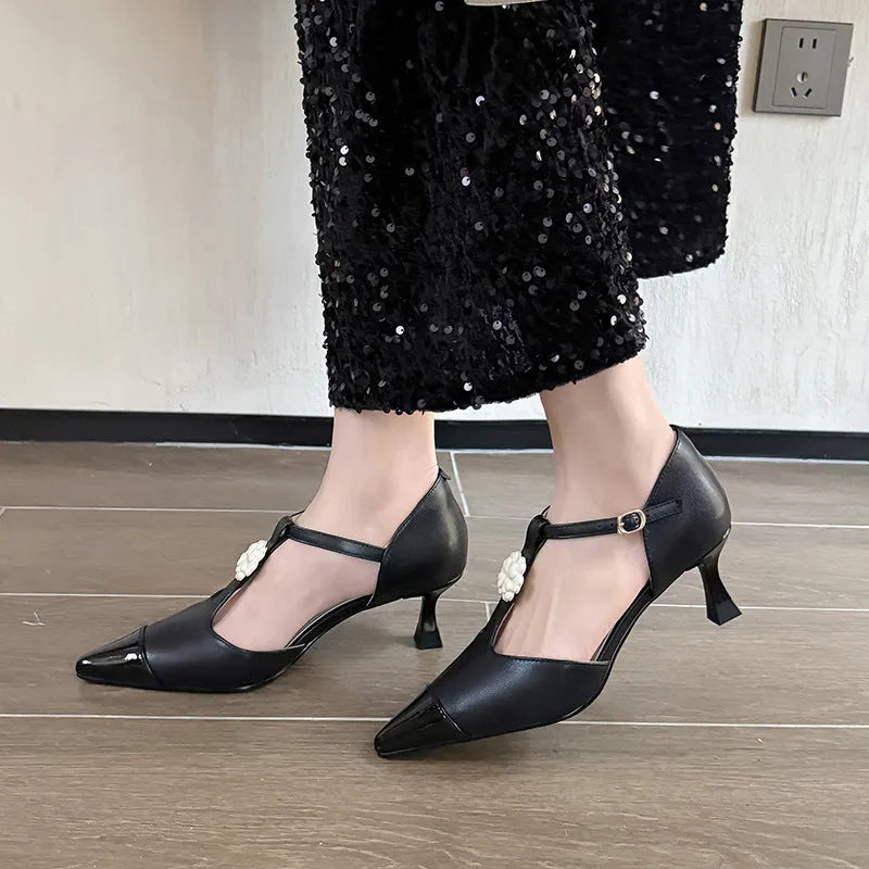 Gold women's stiletto heel shoe with pointed toe, flower buckle, and shallow mouth cut on a beef tendon sole.