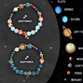 Set of two natural stone beaded bracelets showing zodiac sign charms on a wooden surface.