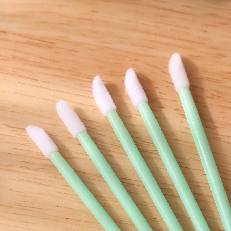 Pack of disposable lip brush wands with flocked brush tips and coloured handles.