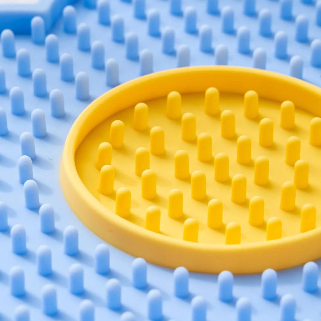 Flower-shaped silicone lick pad for cats and dogs with multiple suction cups on the back, shown in a choice of colours.