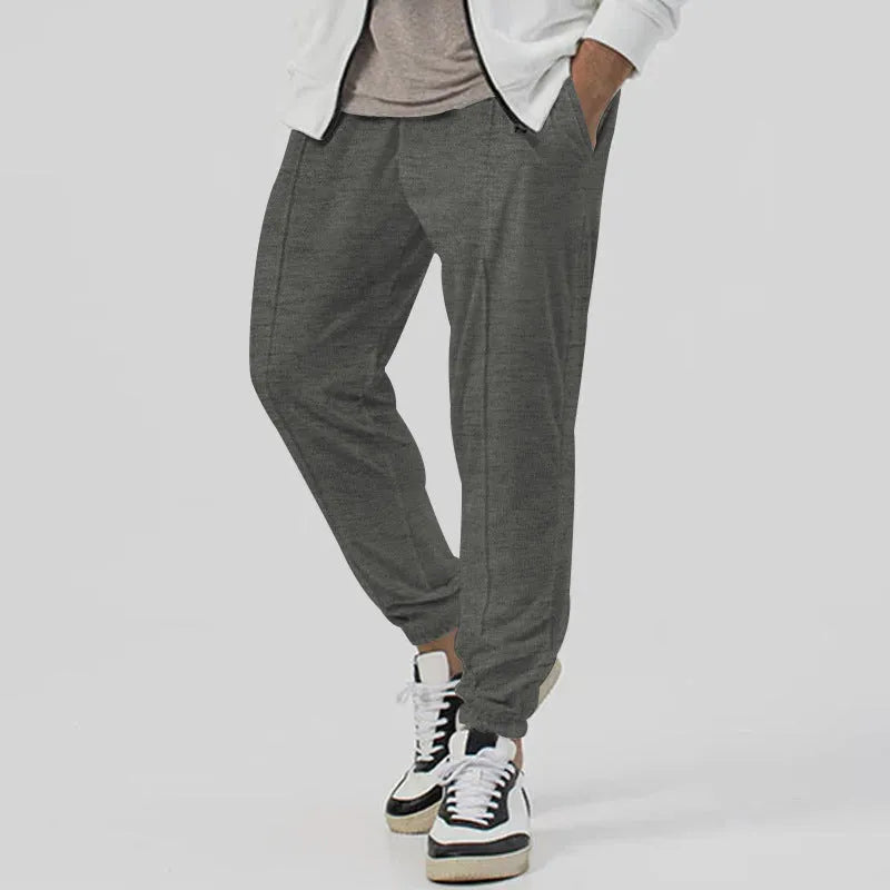 Men's grey track sweatpants with elastic waistband and straight-leg tapered fit
