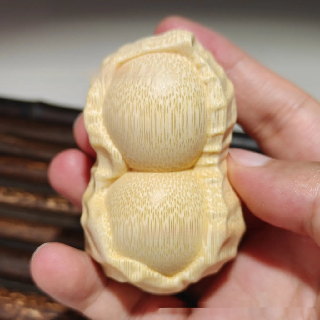 Solid natural bamboo carved peanut ornament with modern simple design on a wooden surface.
