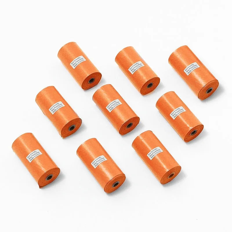 Rolls of green, black, blue, purple and orange degradable pet poo bags with a portable dispenser