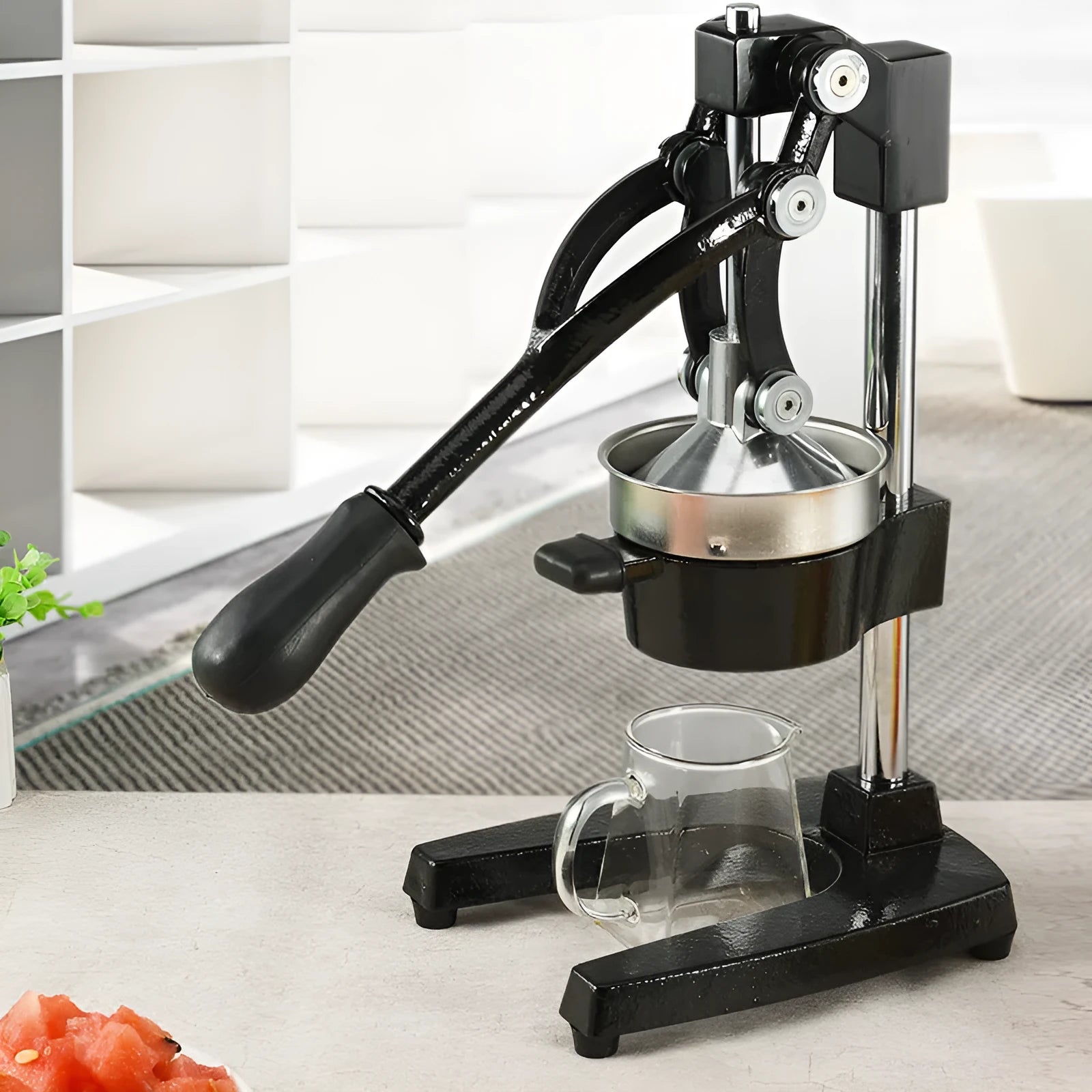 Manual citrus juicer with cast iron base and stainless steel strainer in black or white finish