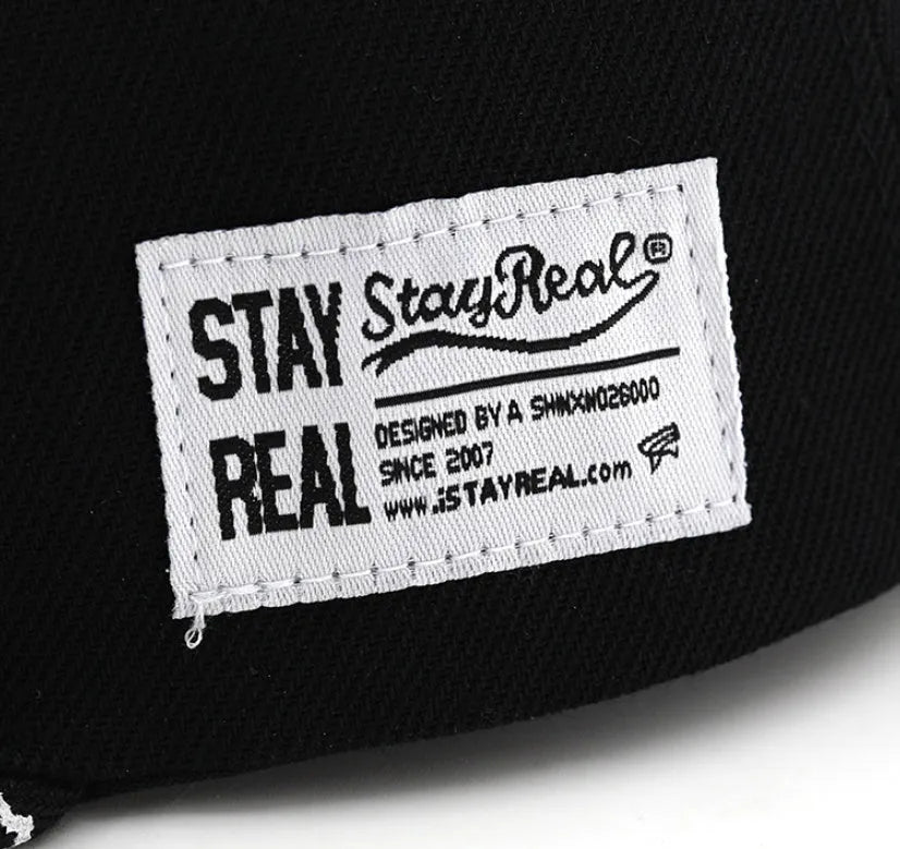 Cotton baseball cap with embroidered letters on the front, shown in black and white colours.