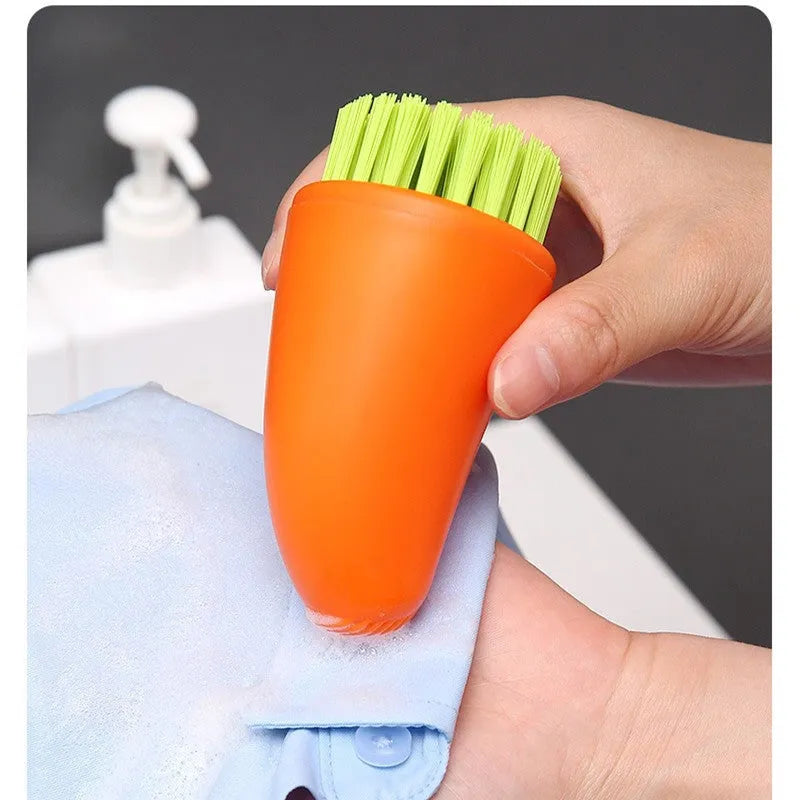 Orange and white carrot-shaped kitchen brush with nylon bristles for scrubbing.