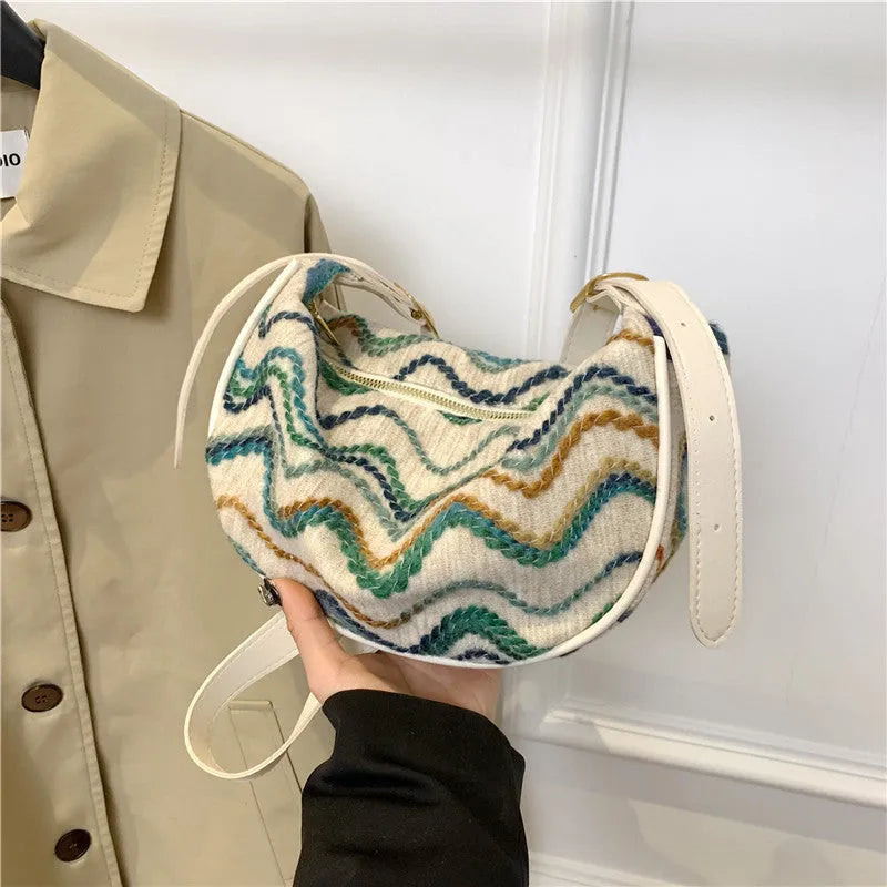 Women's straw woven crossbody bag showing woven texture and internal phone and document compartments