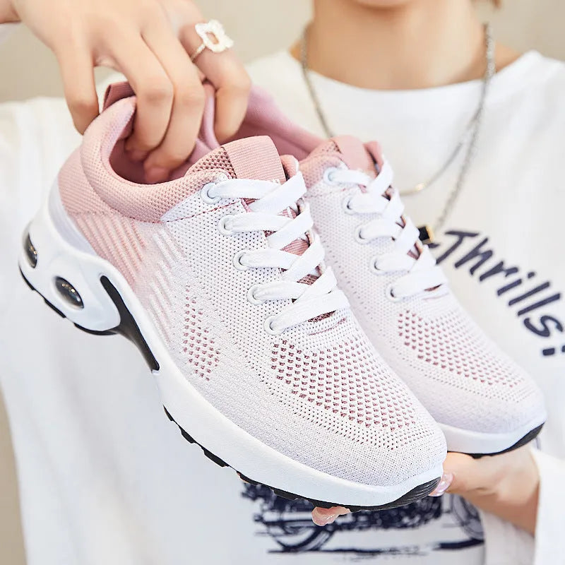 Women's Flyknit casual running shoes in pink with lace-up front and flat PVC sole.