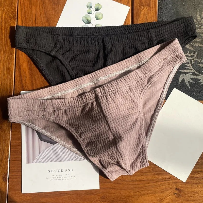 Men's solid colour cotton triangle briefs in mid-waist style, shown in apricot and black colour options.