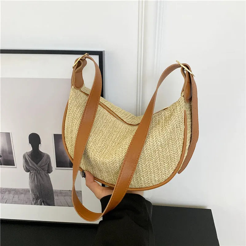 Women's straw woven crossbody bag showing woven texture and internal phone and document compartments