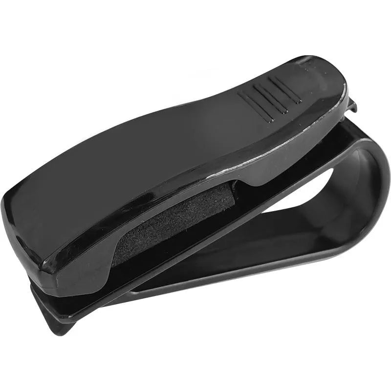 Black plastic car sunshade clip for holding glasses and cards on a vehicle visor.