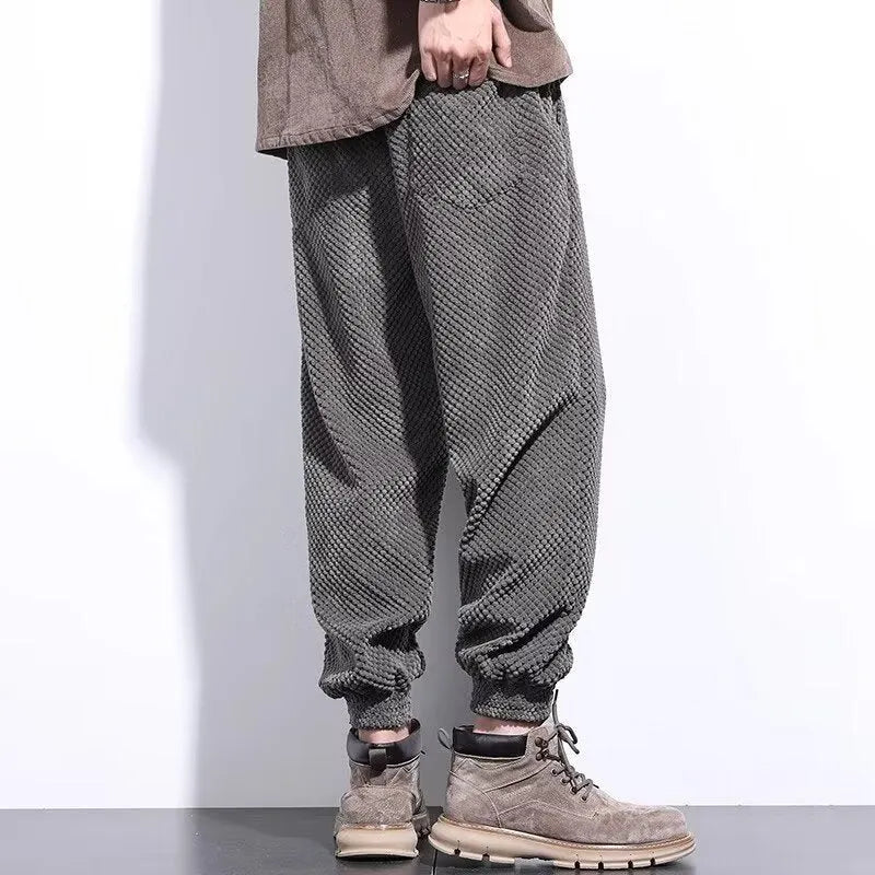 Men's grey straight-leg sweatpants with ankle ties on a plain background.