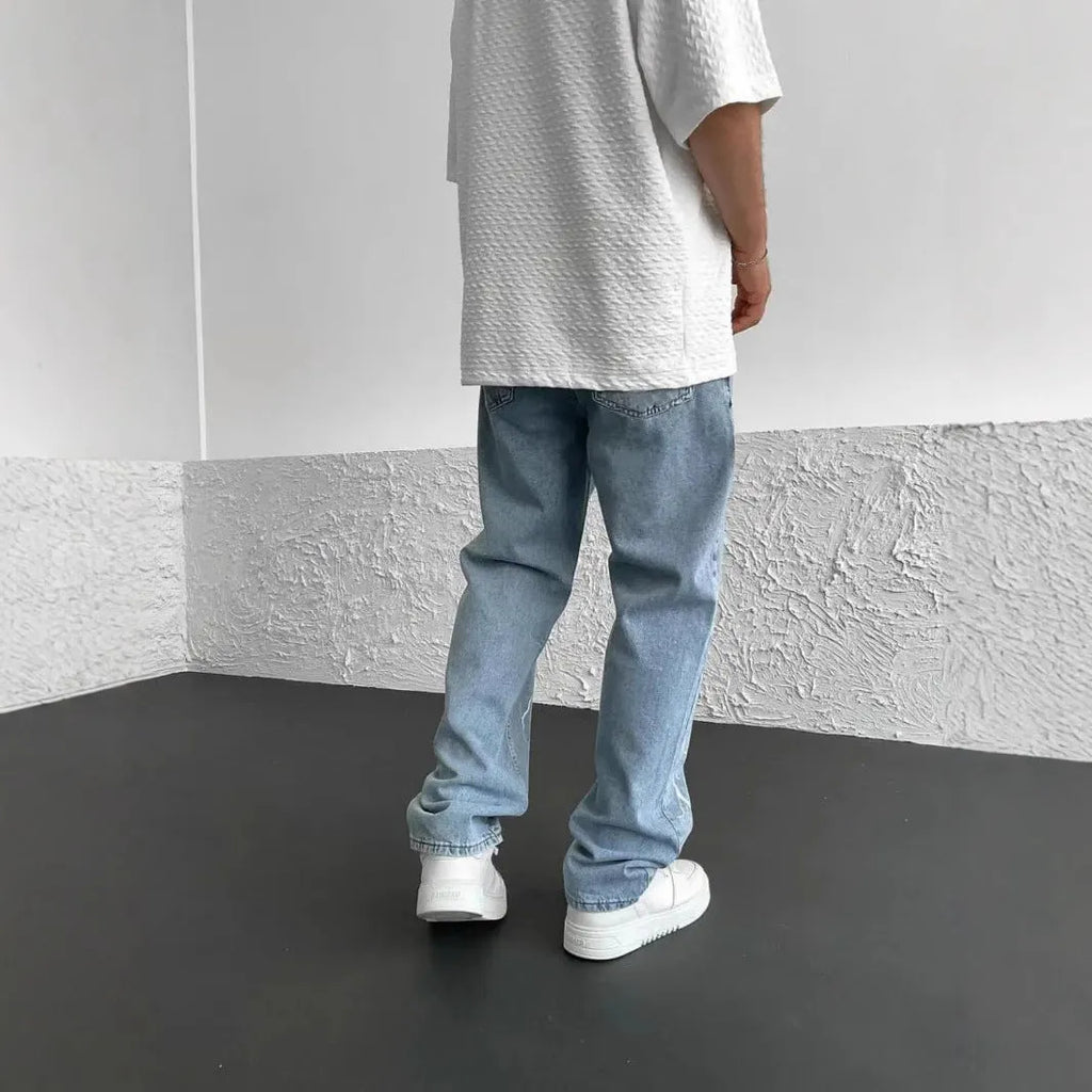 Men's blue straight-leg denim jeans with mid-waist design and loose wide-leg silhouette