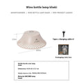 Beige wine bottle shaped camping lantern with USB-C port shown on a table.