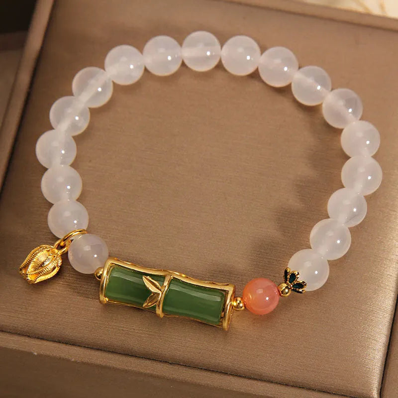 Women's white agate jade bracelet with bamboo joint beads on a wrist.