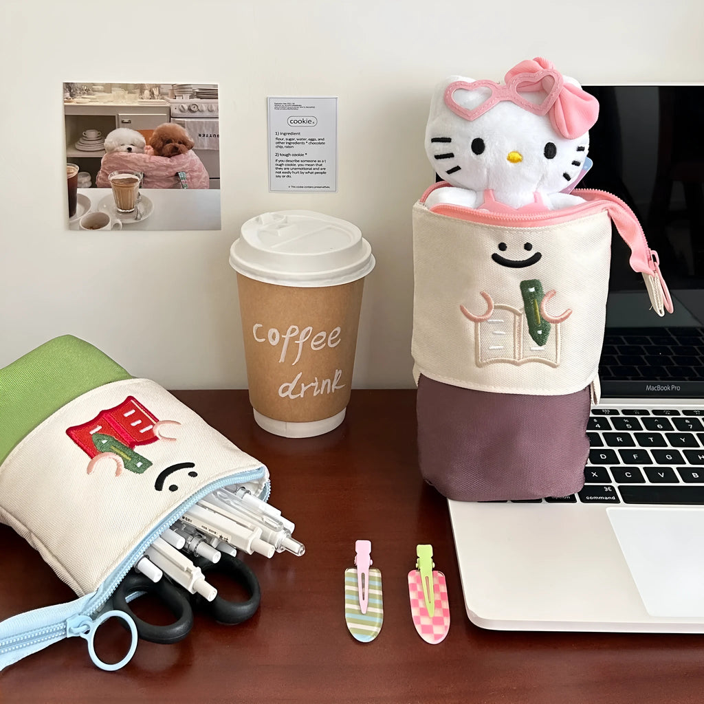 Brown and green cartoon-style collapsible Oxford cloth pencil case showing zip and 17x14cm size.